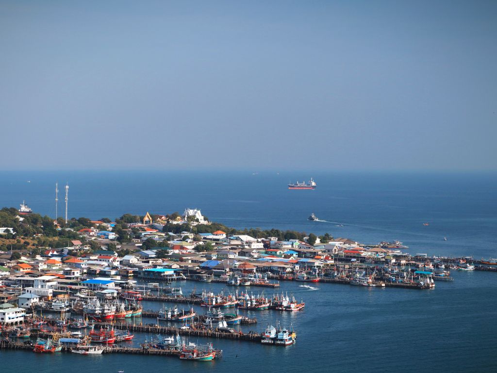 Aerial view of a vibrant fishing village and harbor in Thailand.