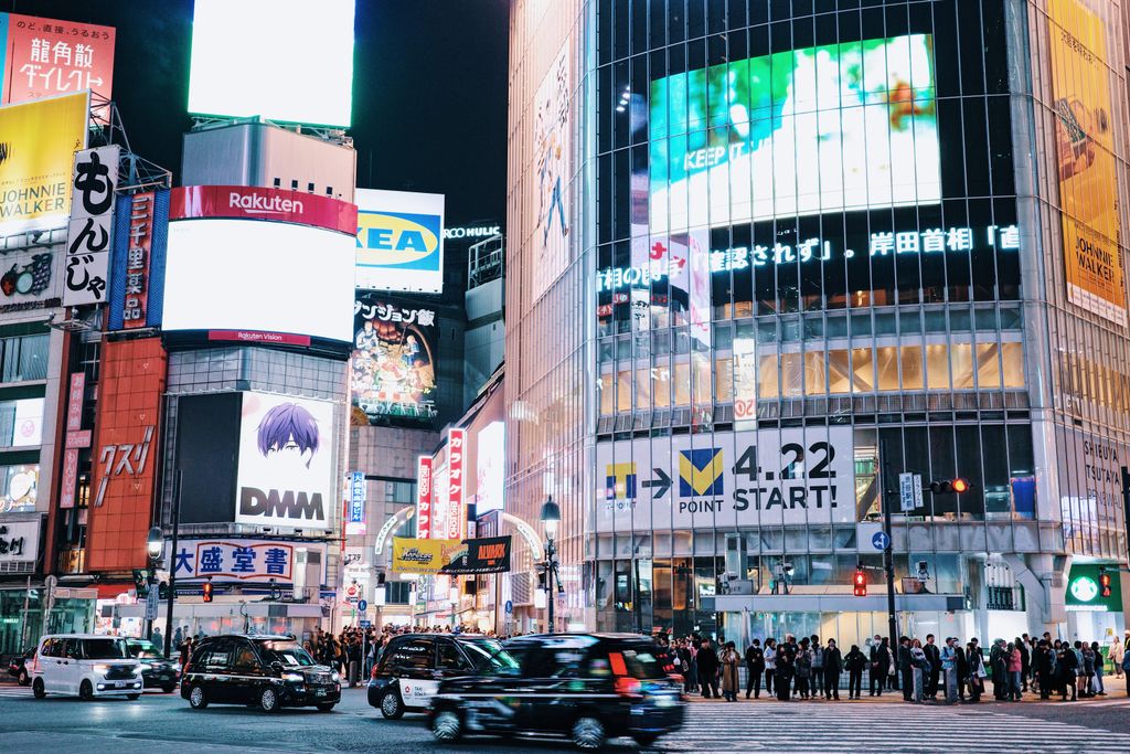 Bustling Shibuya Crossing in Tokyo illuminated at night with crowds and neon signs.